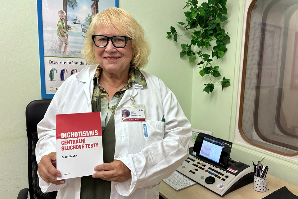 Docentka Olga Dlouhá se svou novou knihou Dichotismus. V pozadí audiometr, který umožňuje specializovaná vyšetření sluchu, a audiometrická kabina. Docentka Olga Dlouhá se svou novou knihou Dichotismus. V pozadí audiometr, který umožňuje specializovaná vyšetření sluchu, a audiometrická kabina.